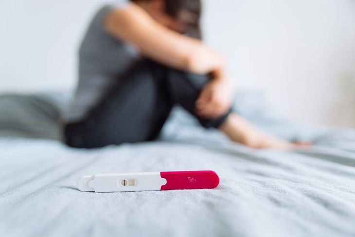 załamana kobieta z negatywnym wynikiem testu ciążowego